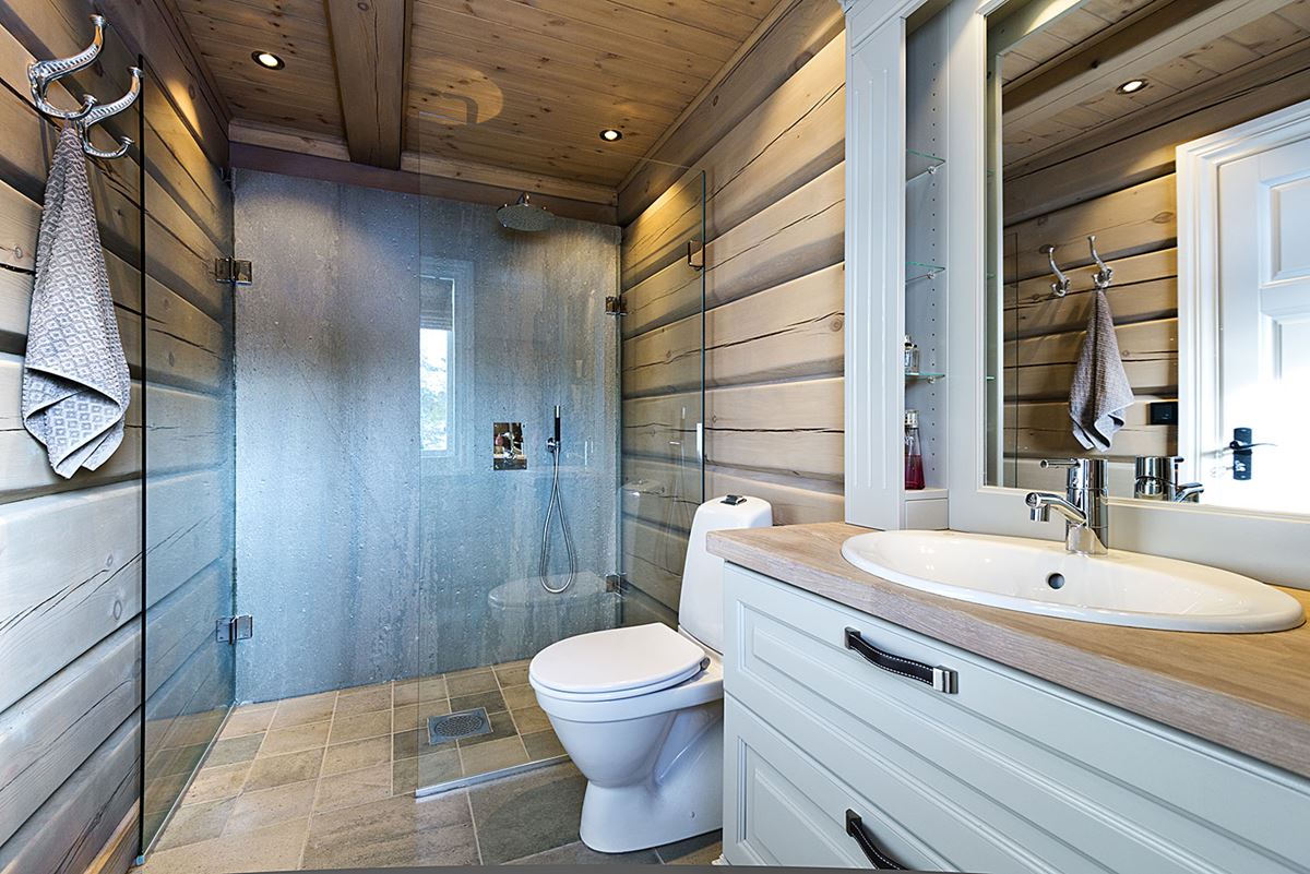 Et lyst og moderne baderom med vegger av laftet treverk