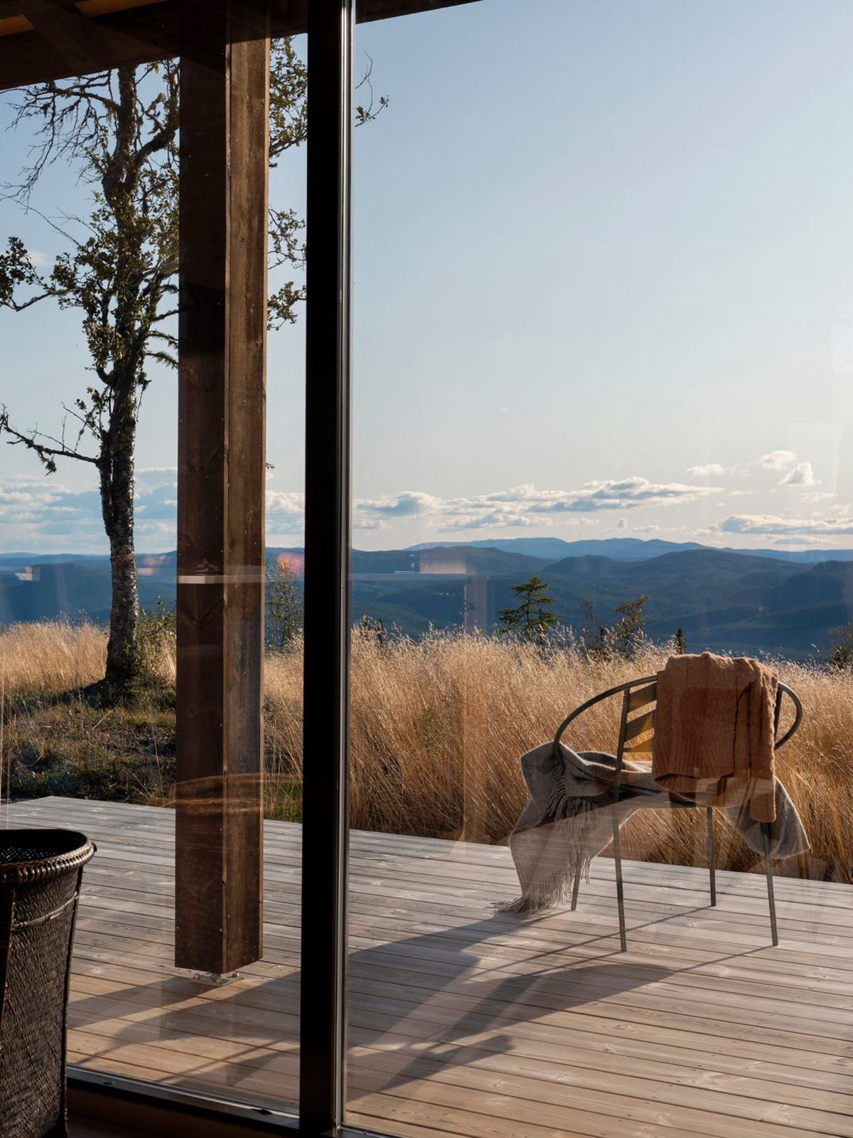 En trelagt terrasse leder ut mot en panoramautsikt med majestetiske fjelltopper